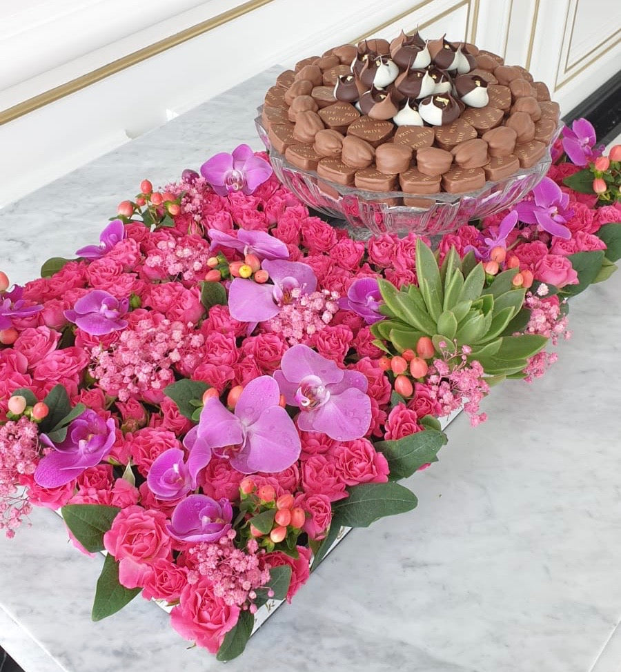 Luxury Orchids & Pink Flower Bed with Glass Bowl of Chocolates